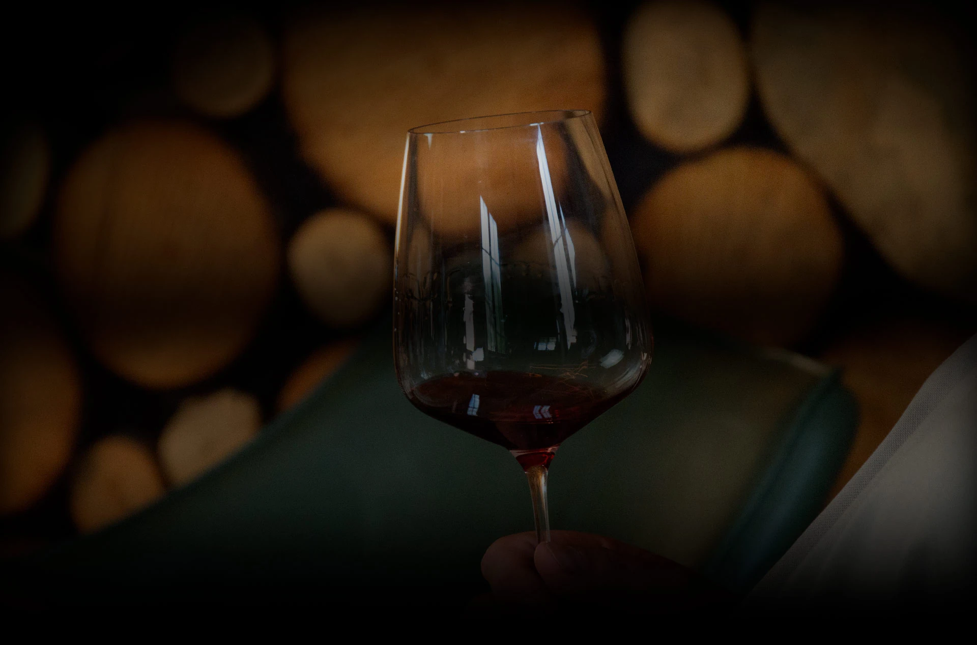 Copa de vino tinto sobre barricas de madera en Albanta Cocina de Leña, Vilaboa (Pontevedra)